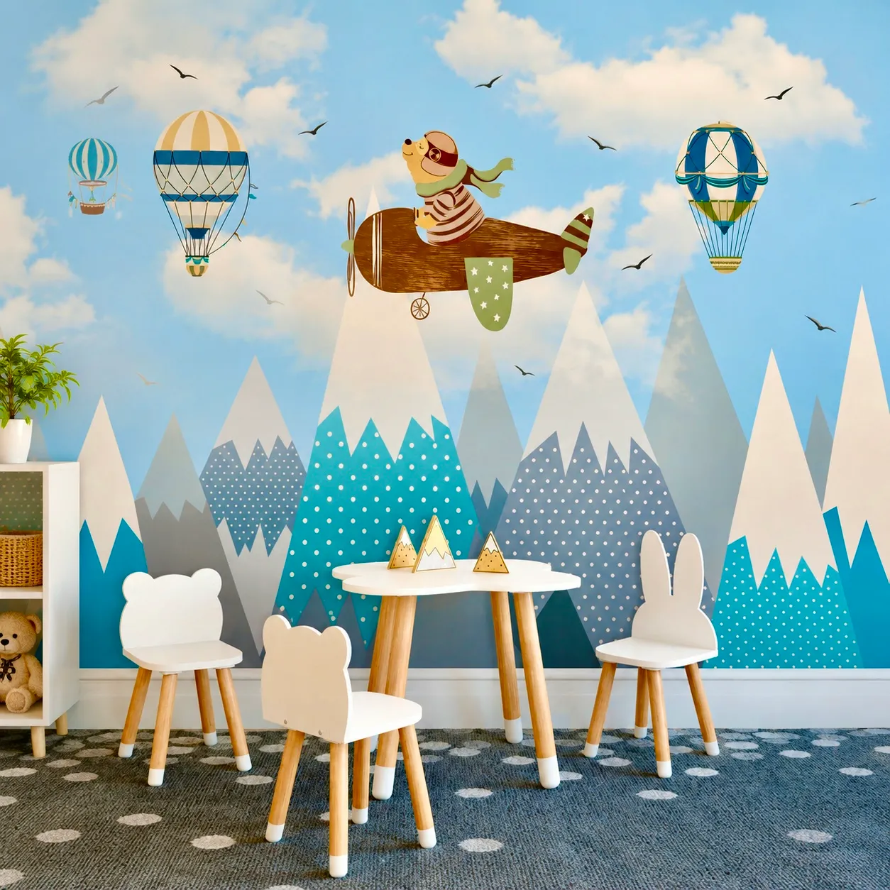 Blue mountain mural with a bear flying a plane between hot air balloons